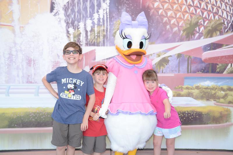 Three children with Daisy Duck at Disney World