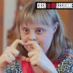 Girl with Down syndrome makes heart gesture with hands